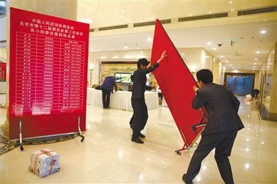 昨日,五洲大酒店政协委员驻地,工作人员正准备搭建指示牌。